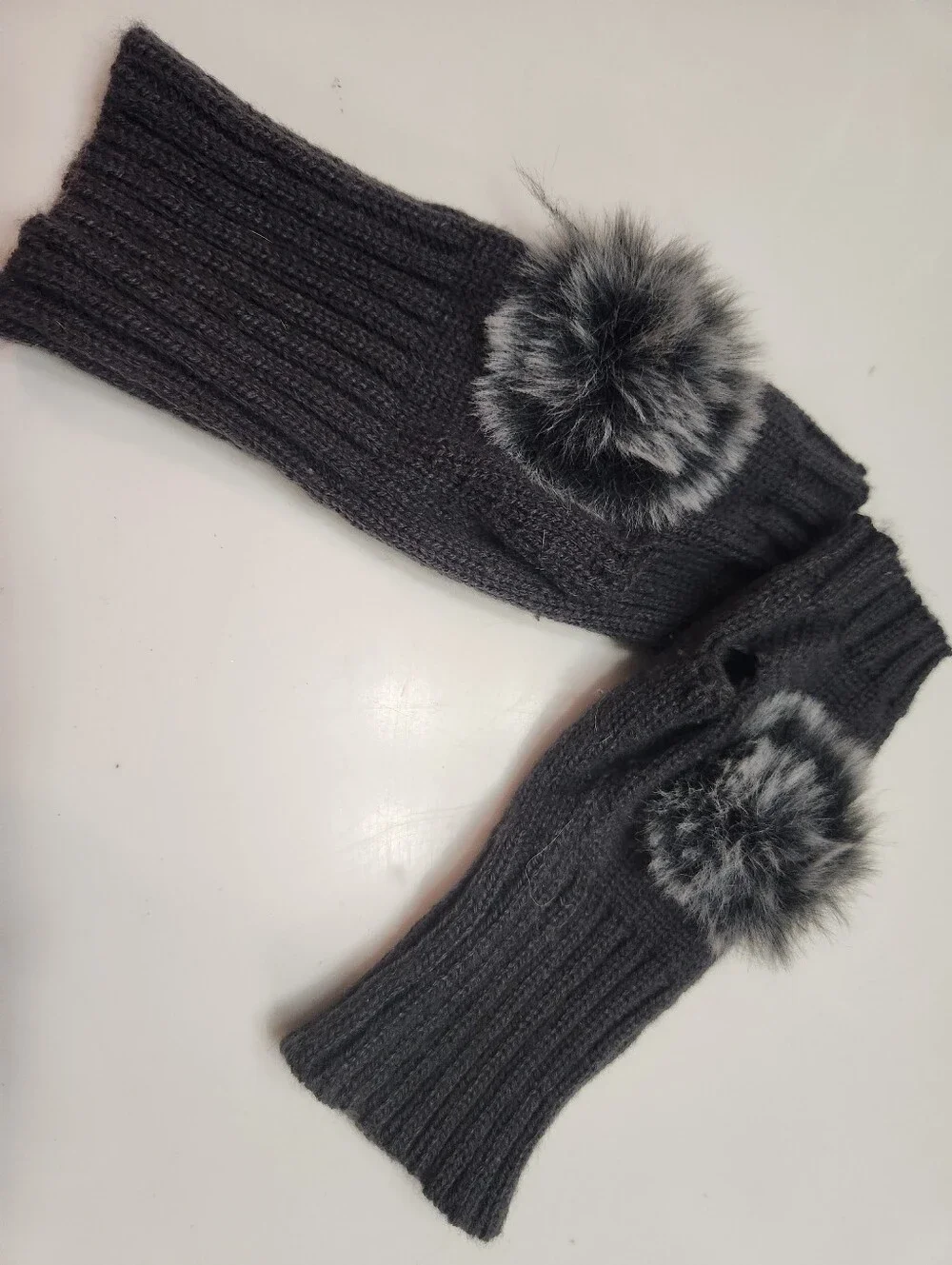 Dark gray women's winter fingerless knit gloves featuring a ribbed texture